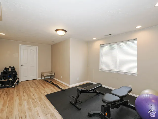 Wood-finish flooring, recessed lighting, neutral wall tones, and a window with blinds