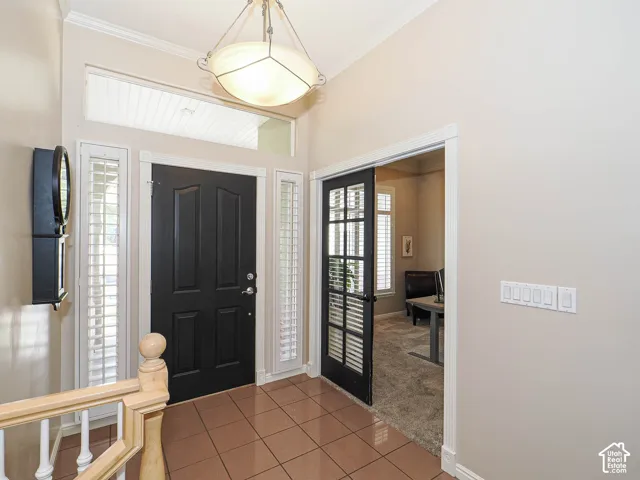 Entryway featuring a dark paneled door, transom window, sidelights with interior shutters, recessed lighting, and tile flooring