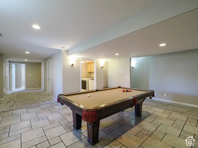 Recessed lighting, wall sconces, mixed flooring with tile and carpet, and a separate laundry area with cabinetry