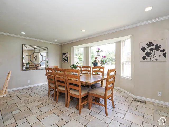 Recessed lighting, crown molding, bay window, tile flooring, and neutral wall tones