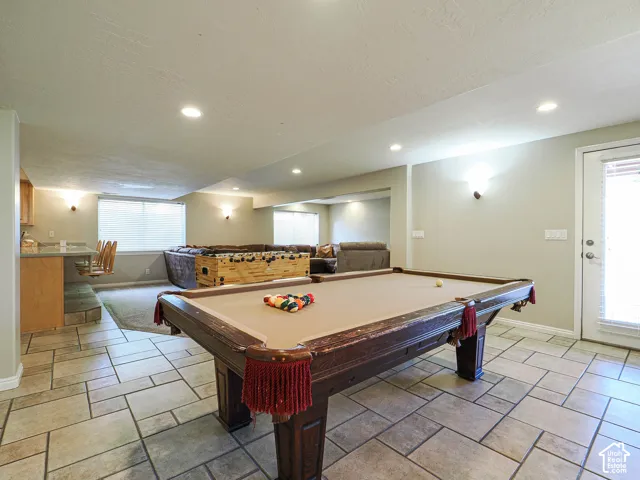 Spacious entertainment area featuring a full-light door, recessed lighting, and wall sconces
