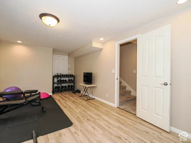 Wood-finish flooring, recessed lighting, ceiling-mounted fixture, white paneled doors, and carpeted stairs