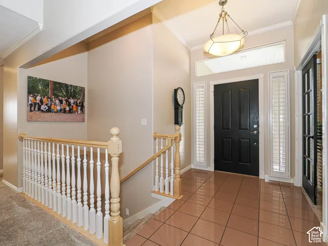 Entry foyer featuring tile flooring, a dark paneled door, and sidelight windows with white shutters
