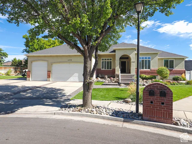 Stucco exterior with a hip roof, arched entry, and a two-car garage
