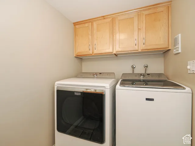 Wood-finish upper cabinetry with silver-tone hardware, providing storage
