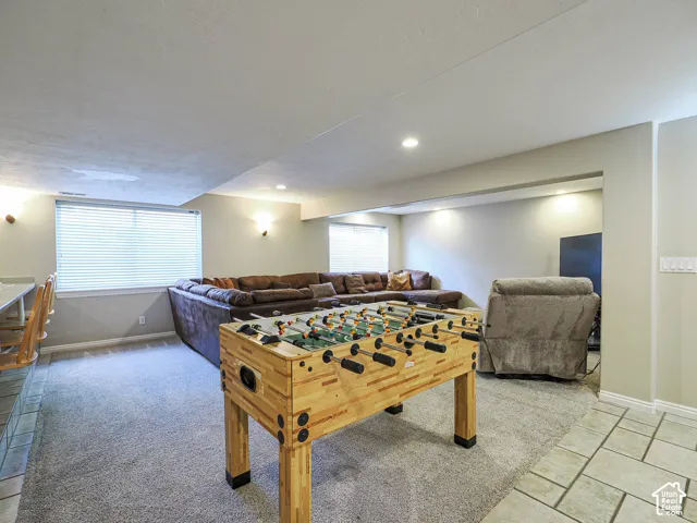 Recessed lighting, light gray carpet flooring, tiled flooring, built-in counter seating, and multiple windows