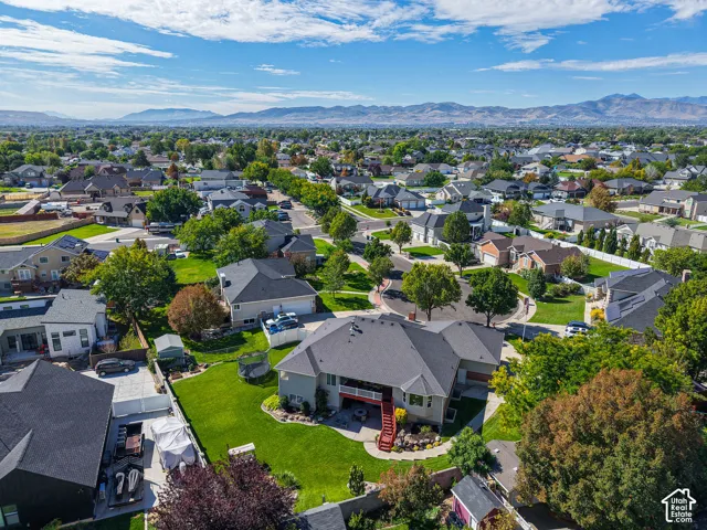 Expansive neighborhood setting featuring a consistent housing style, mature trees, and distant mountain backdrops