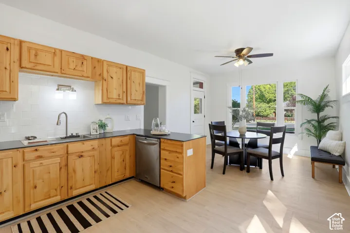 Natural wood cabinetry with a stainless steel sink and appliances