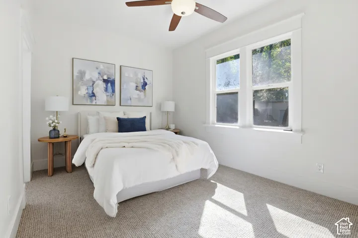 Carpeted flooring, white walls, and a ceiling fan with integrated lighting