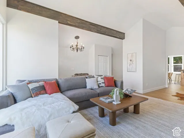 Vaulted ceilings, wood-finish beam accents, recessed lighting, and wood-finish flooring