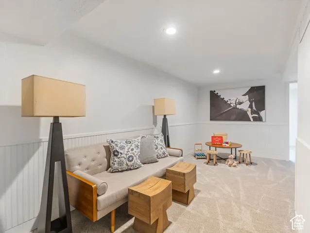 Recessed lighting, wainscoting, and neutral-toned carpeting