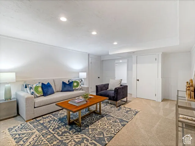 Recessed lighting illuminates this space featuring paneled wall accents and a dropped ceiling element