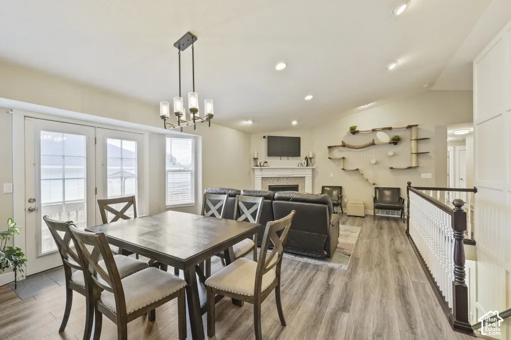 Open-concept living space featuring vaulted ceilings, recessed lighting, and wood-finish flooring
