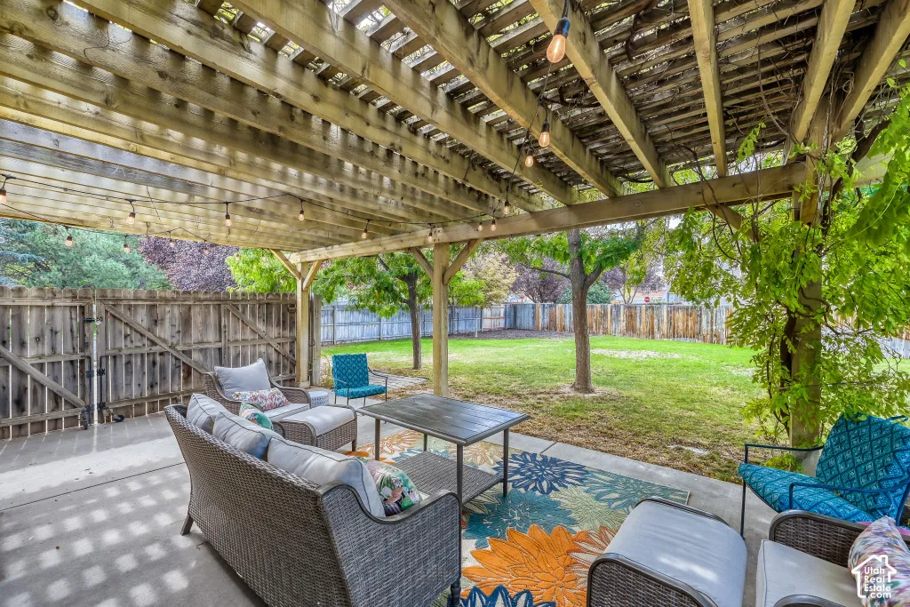 Expansive backyard featuring a wood pergola, string lighting, mature trees, a privacy fence, and a concrete patio
