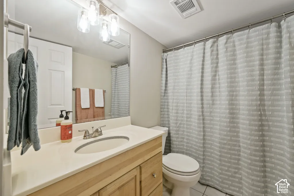 Light wood-finish vanity with a light-toned countertop, set under a large mirror