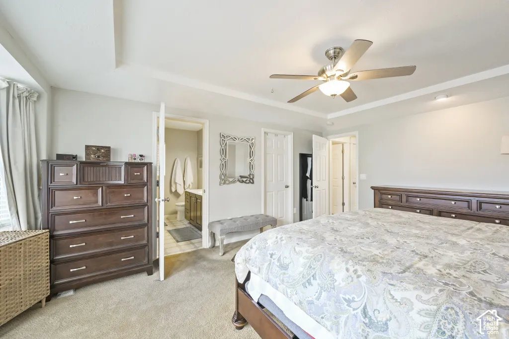 Recessed lighting, ceiling fan with light fixture, tray ceiling, and a bathroom with vanity and mirror