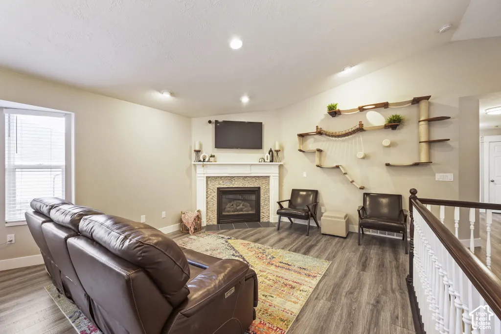 Living space featuring a fireplace with a decorative tile surround and mantel, recessed lighting, and wood-finish flooring