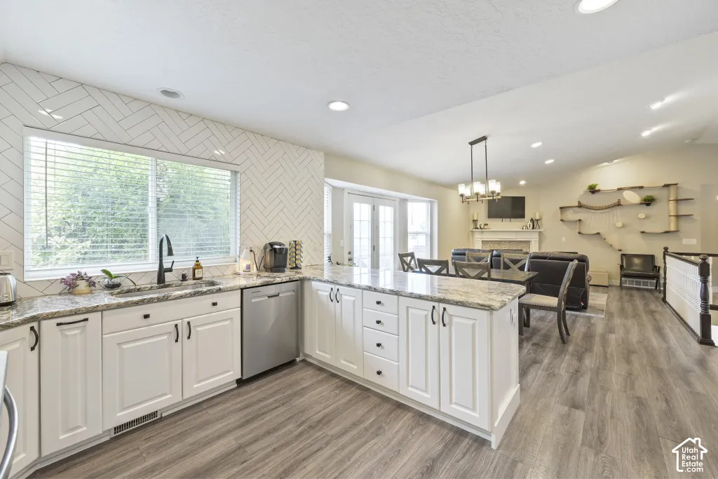 Kitchen featuring white cabinetry, a herringbone tile backsplash, and stainless steel appliances