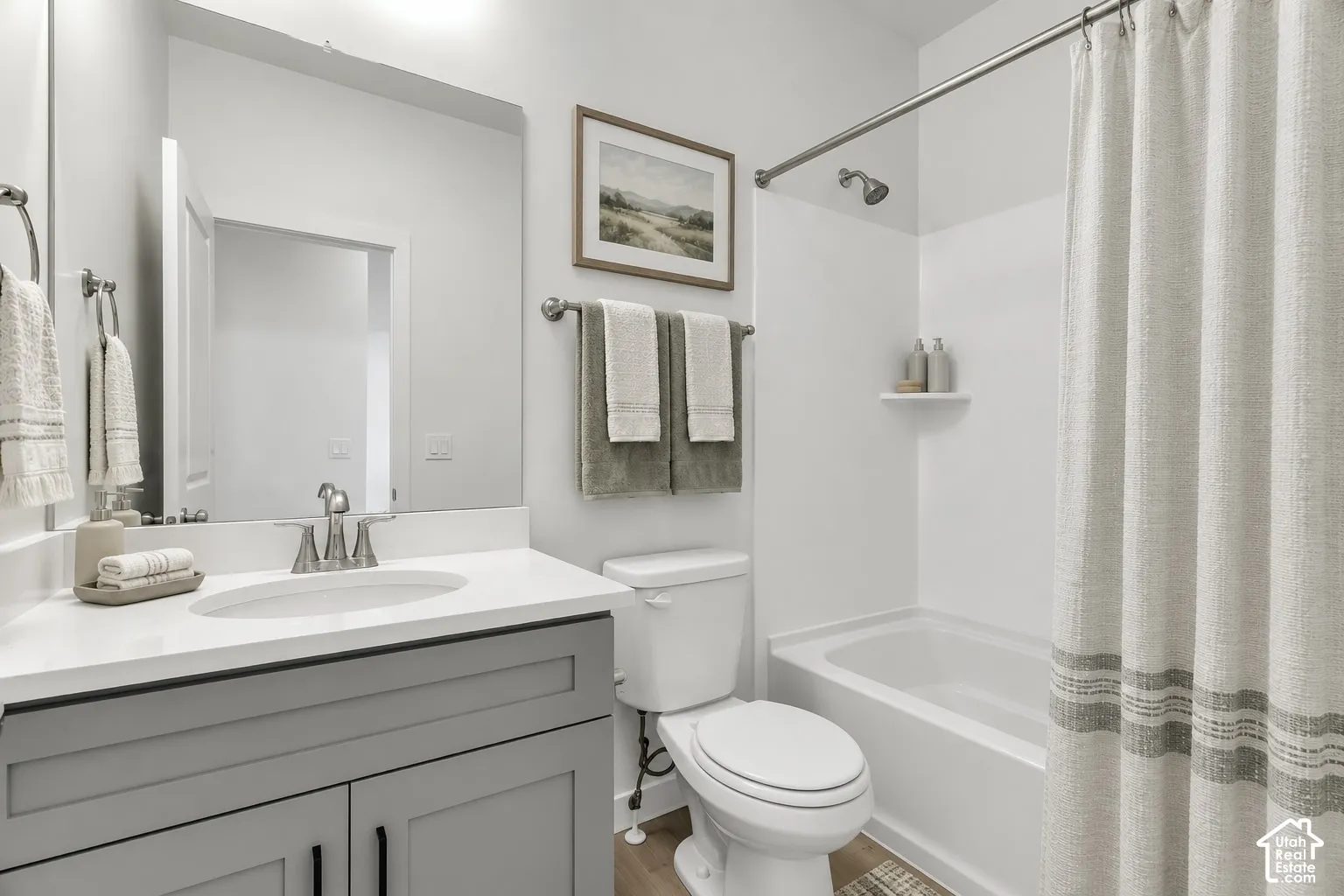 Bathroom featuring a tub/shower combination, single vanity with a white countertop, and a built-in shelf