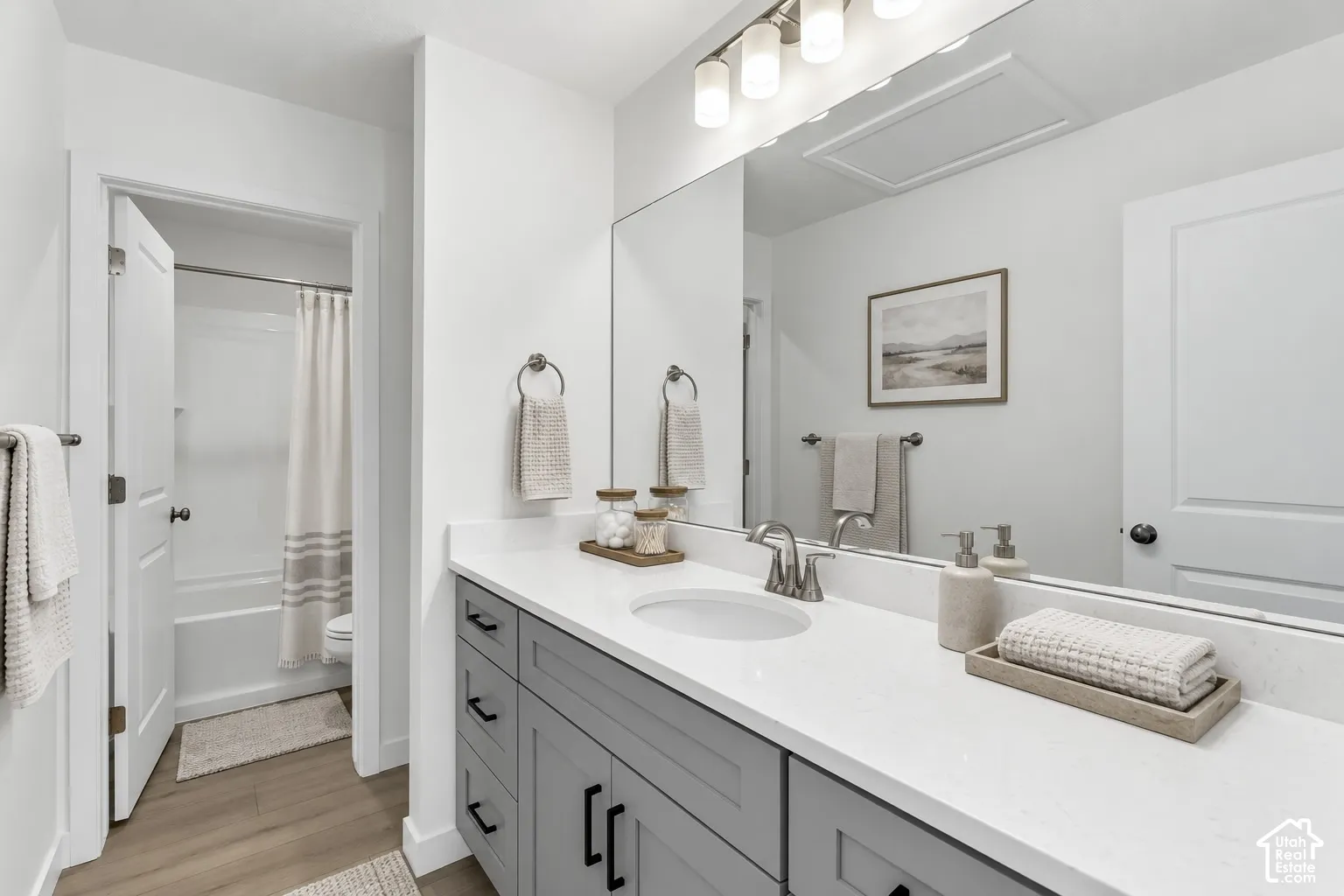 White vanity featuring a white countertop with an undermount sink and brushed nickel faucet