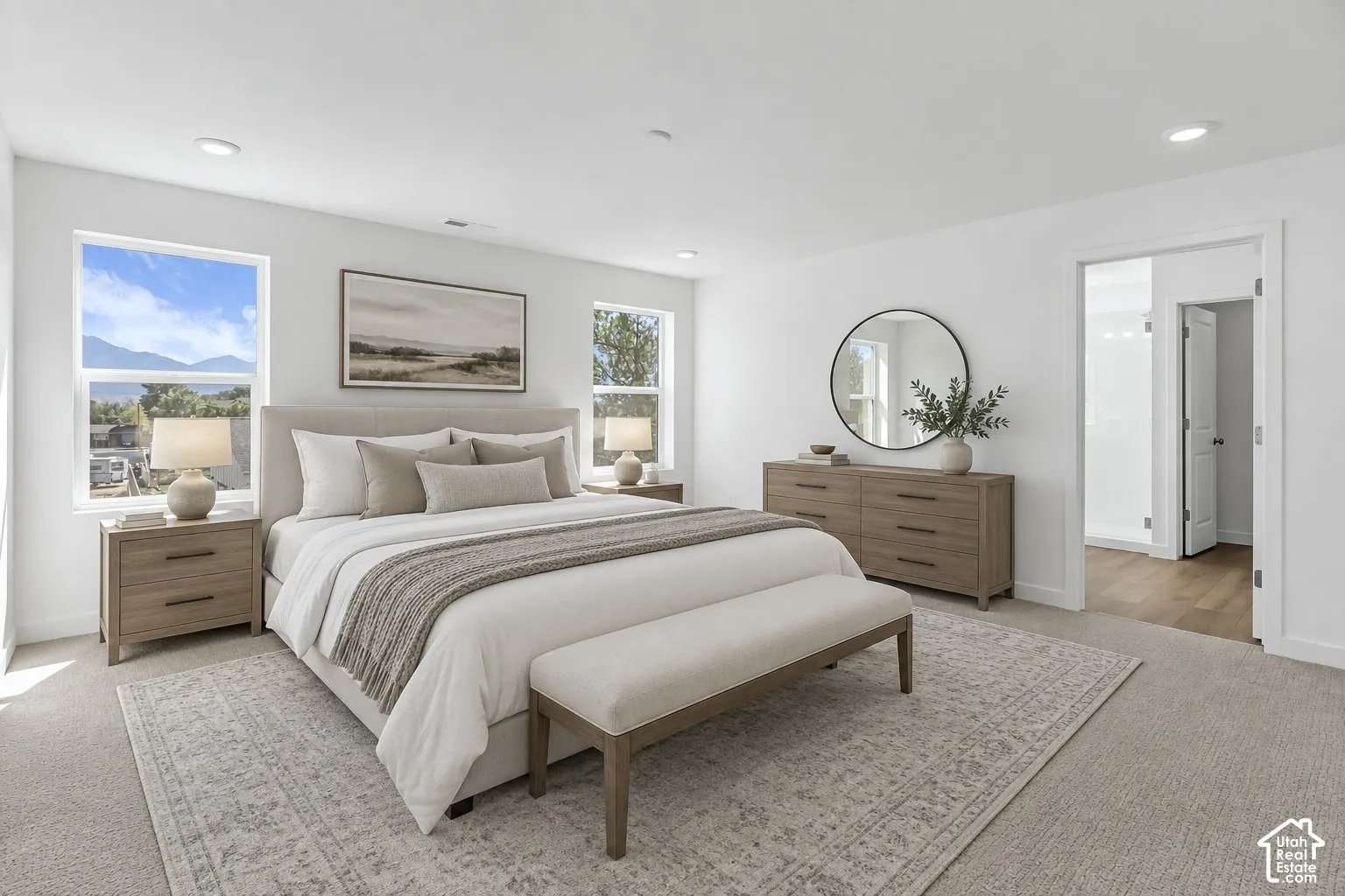 Recessed lighting, light-toned carpeting, white walls, and a doorway with a hinged door
