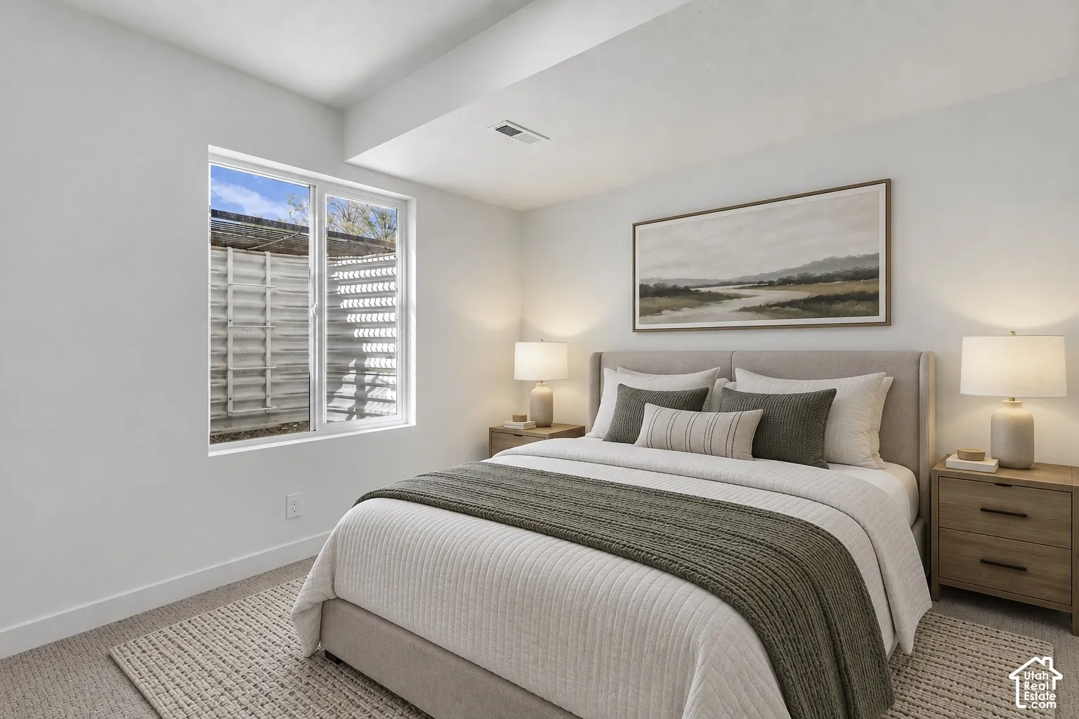 Recessed lighting, wood-finish bedside tables, wall-mounted artwork, and a window with a slatted exterior feature