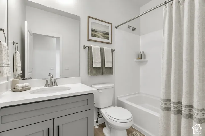 Bathroom featuring a tub/shower combination, single vanity with a white countertop, and a built-in shelf