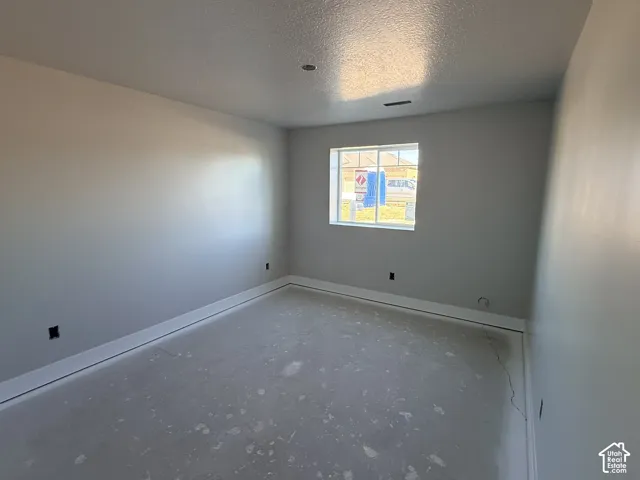 Neutral-toned interior space featuring smooth wall finishes and a single-pane sliding window