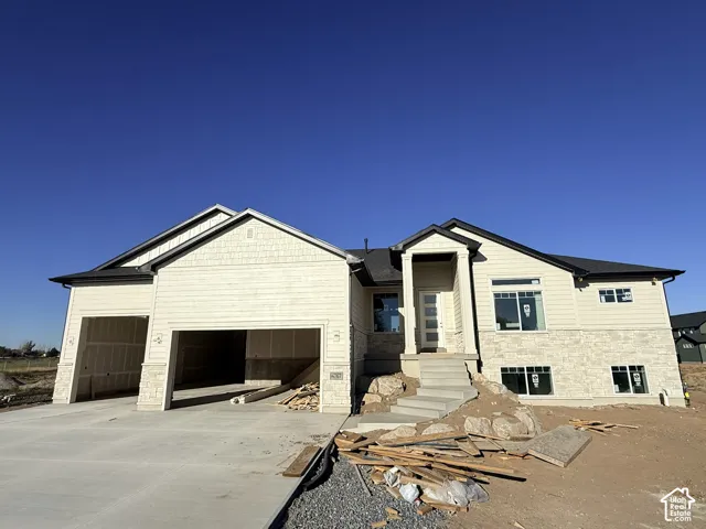 Contemporary exterior with a stone and siding facade, covered entry, and multi-pane front door