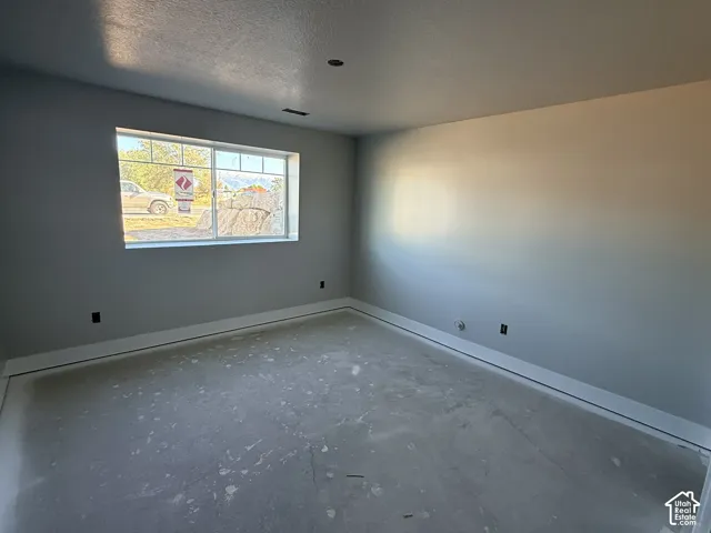 Interior space featuring neutral painted walls, horizontal sliding window with muntins, and textured ceiling finish