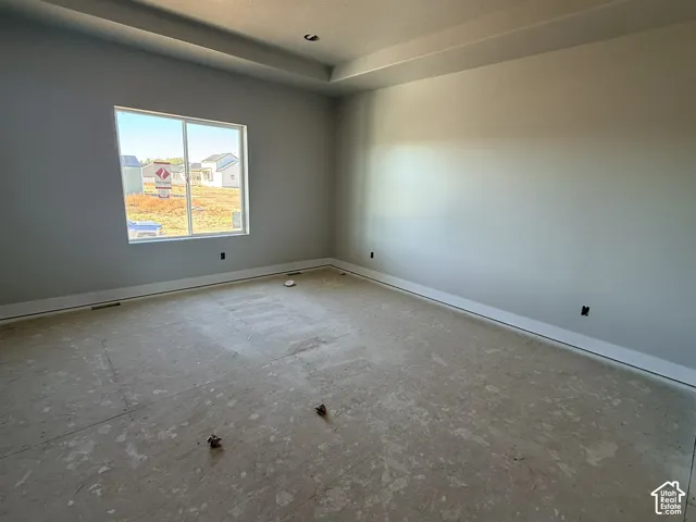 Interior space featuring a recessed tray ceiling and a single-pane sliding window