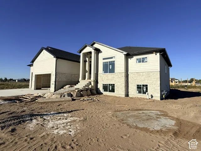 Two-story residence featuring light-colored stone and siding exterior