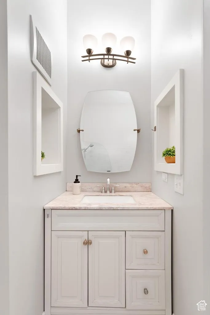 White vanity with an integrated sink, light-toned countertop, and brushed nickel faucet