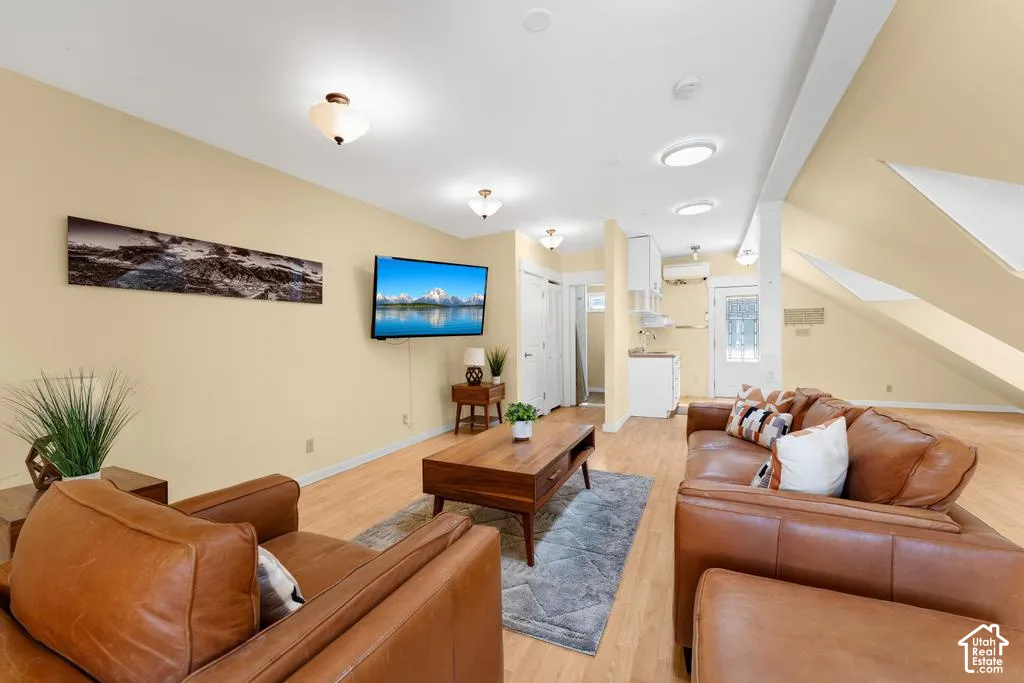 Bright living area with wood-finish flooring, recessed lighting, and a neutral color palette