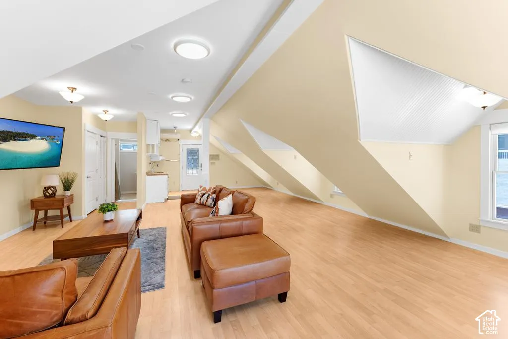 Wood-finish flooring throughout, with sloped ceilings and integrated ceiling lighting