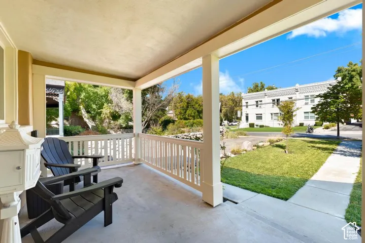 Covered porch with concrete flooring and white railing