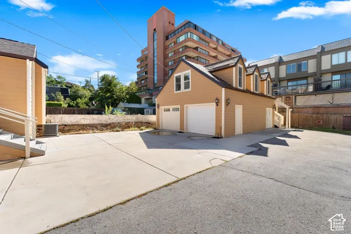 Paved driveway with extensive surface area, two-car garage, and dormer windows