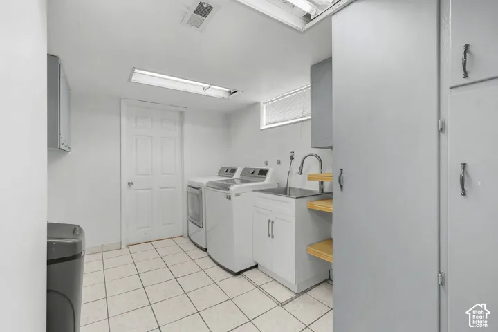 Tile flooring, built-in cabinetry, utility sink, and wall-mounted shelving