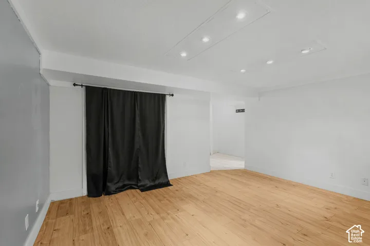 Wood-finish flooring with white walls and recessed ceiling lighting
