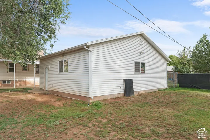 Detached auxiliary structure featuring white siding and multiple windows