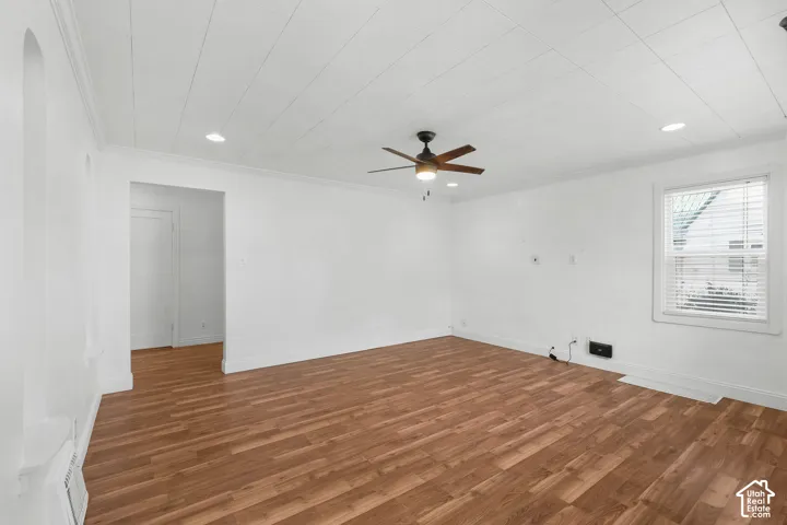 Wood-finish flooring with crisp white walls and crown molding