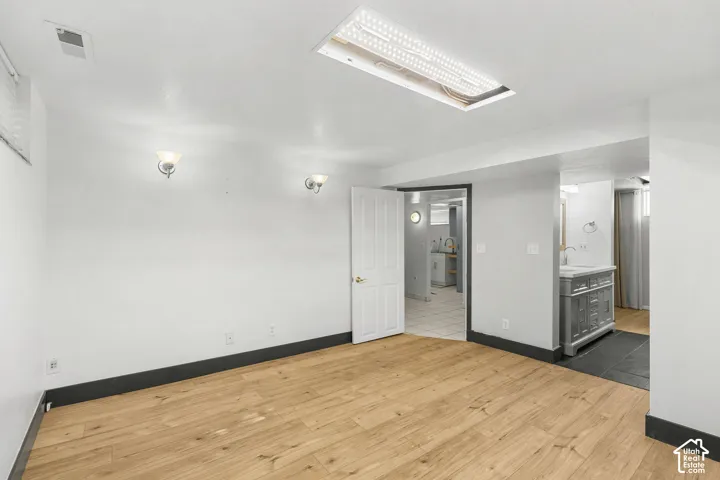 Wood-finish flooring with white walls and dark trim