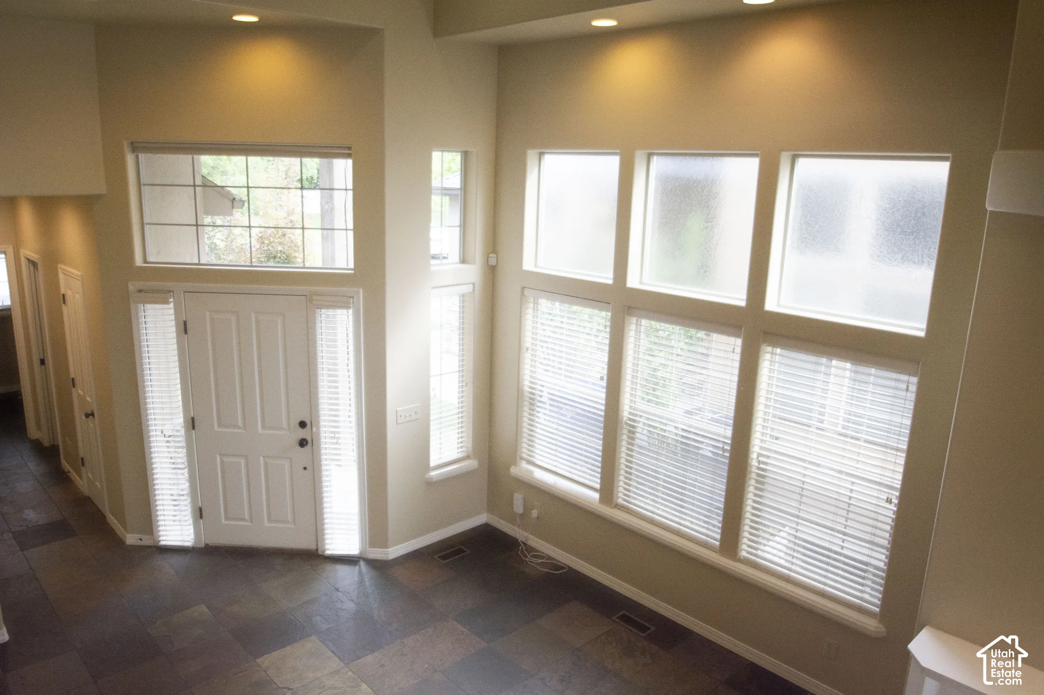 Entryway with a paneled door, transom window, and sidelights