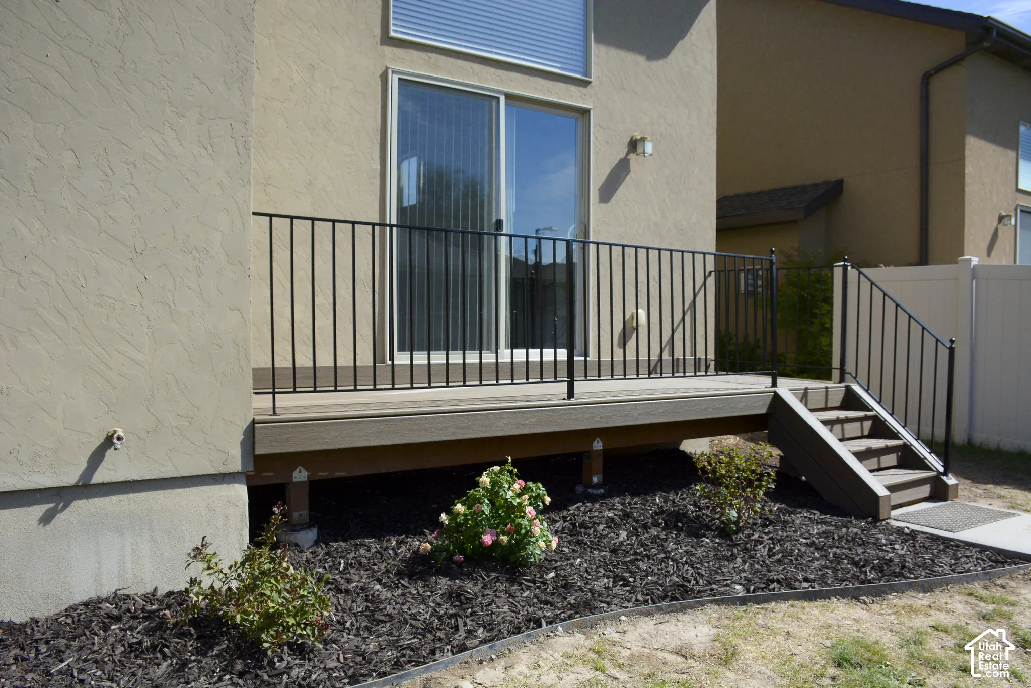 Exterior deck featuring black metal railings and composite wood-finish steps