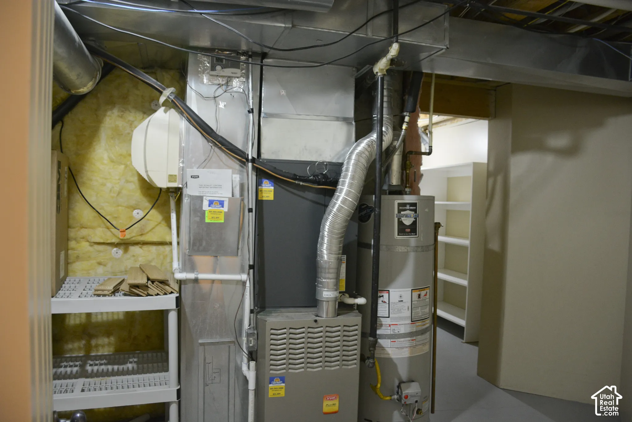 Furnace and water heater with exposed ductwork and ceiling joists