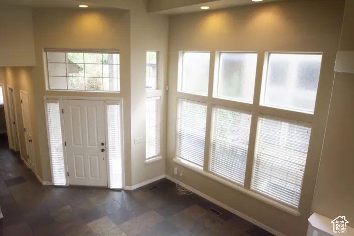 Entryway with a paneled door, transom window, and sidelights