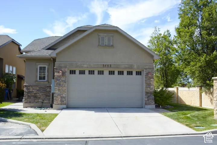 Stucco exterior with stone accents and a sloped roofline