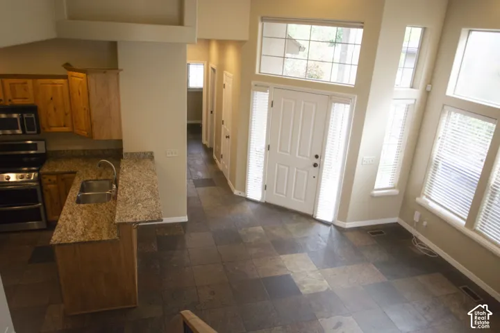 Entry with slate tile flooring, two-story ceiling, and abundant natural light