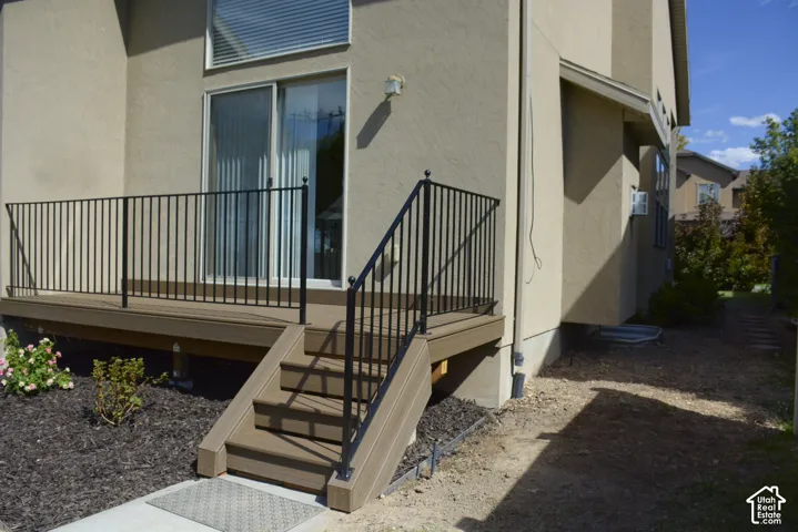 Exterior deck with composite decking, black metal railing, and direct access through a sliding glass door
