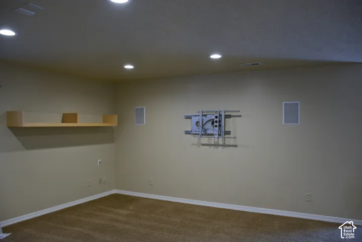 Recessed ceiling lighting, built-in wall speakers, wall-mounted shelving, and a pre-installed TV mount